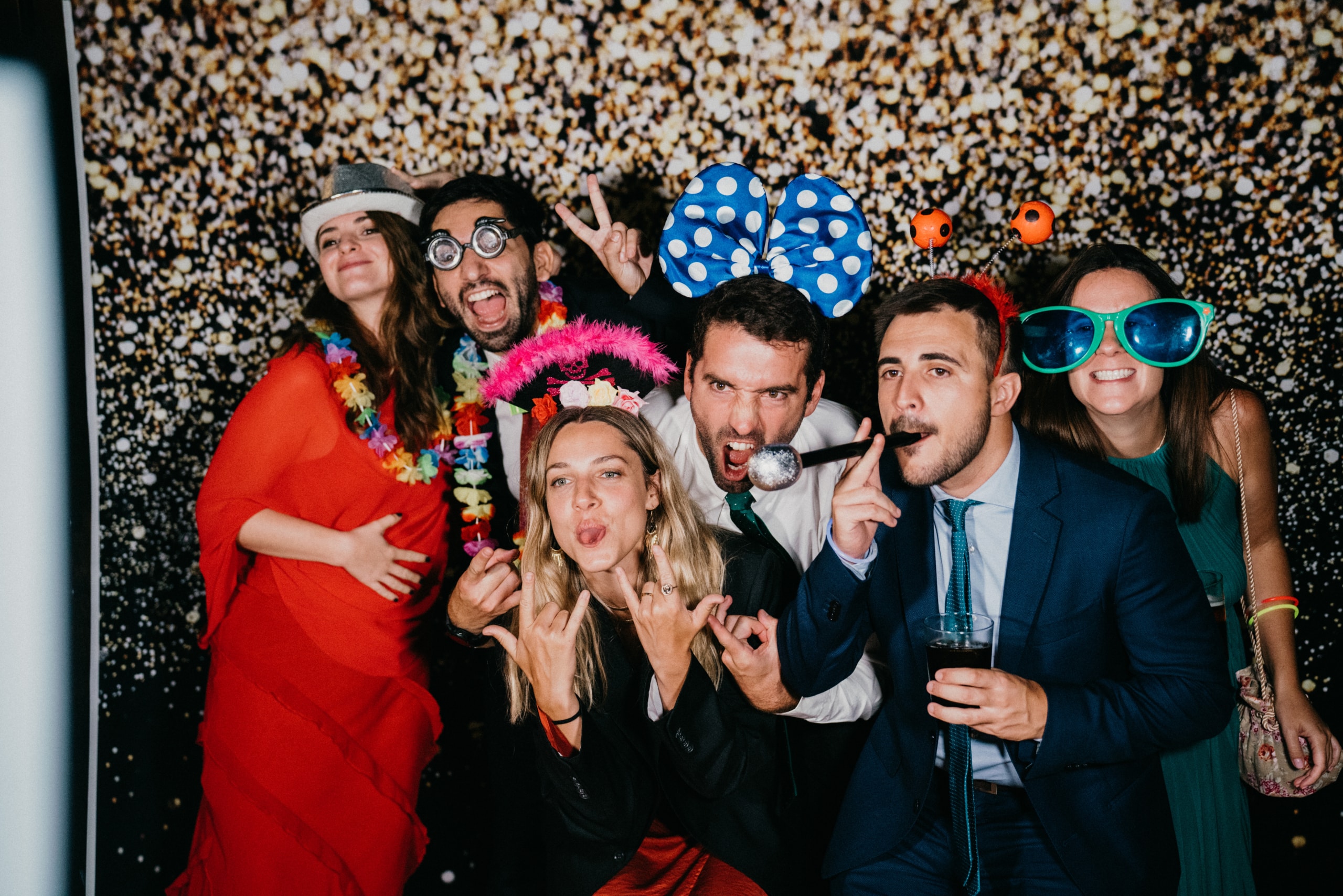 Invitados sonriendo y posando con accesorios en el fotomatón profesional de El Carrete en una boda en Lleida.